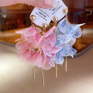 Close-up of elegant floral mesh earrings with silver needles and gold-tone tassels