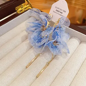 Close-up of elegant blue mesh flower drop earrings presented in a luxury jewelry box