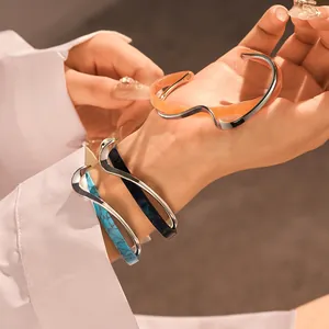 Primo piano di eleganti bracciali in acrilico placcati oro sovrapposti al polso.