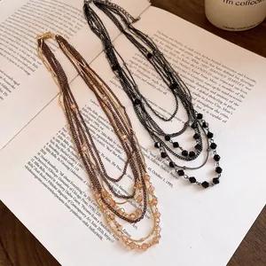 Retro multi-layer necklace with glass beads and layered chain design.