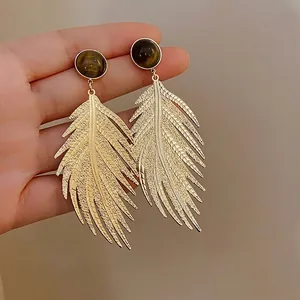 Elegant leaf-shaped gold drop earrings featuring synthetic tiger eye stones and silver needles.