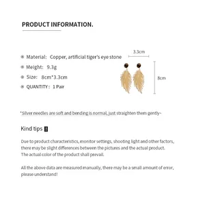 Product specifications of gold feather earrings featuring artificial tiger eye stone