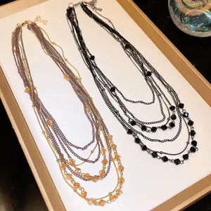 Close-up detail of retro multi-layered necklaces featuring elegant faceted glass beads.
