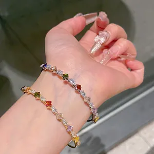 Dettaglio di bracciali rigidi aperti oro e argento con zirconi colorati a forma di stella