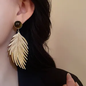 Detailed close-up view of high-quality vintage gold leaf earrings with faux tiger eye stone