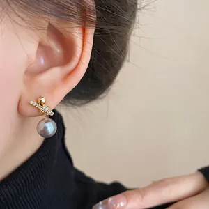 Elegant gold plated earring with zircon cross ribbon and grey pearl.