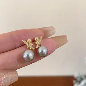 Elegant gold-plated stud earrings featuring grey pearls and sparkling zircon knot designs
