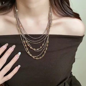 Close-up of elegant multi-layered necklace with amber glass beads on a model.