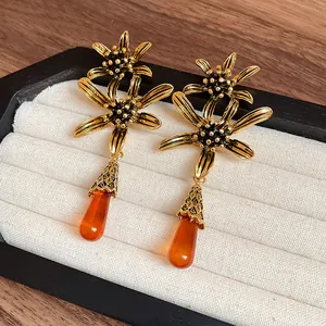 Detailed view of vintage flower earrings with amber resin teardrop pendants