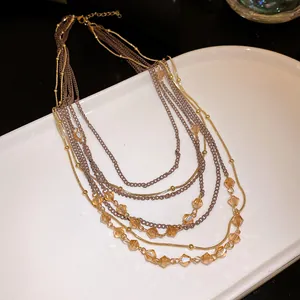 Close-up of elegant vintage multi-layer necklace with amber glass beads and gold chains.