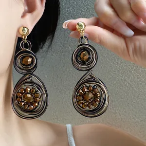 Primer plano detallado de pendientes tejidos vintage con cuentas marrones talladas