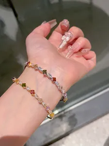Dettaglio di bracciali aperti in oro e argento con zirconi colorati a forma di stella