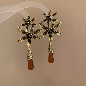 Close-up of vintage gold flower earrings with amber resin water drop tassels