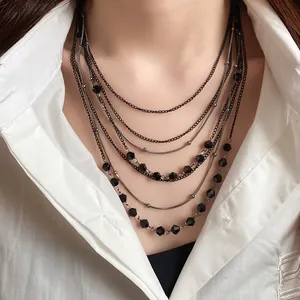 Detailed view of a multi-layered vintage necklace with black glass beads on model