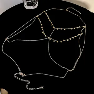 Close-up detail of an elegant multi-layer gold sequin body chain on a black background.