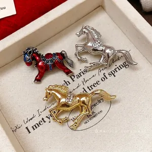 Elegant horse-shaped brooches with sparkling rhinestones in gold, silver, and red enamel.