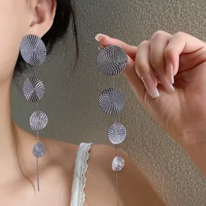 Long textured silver dangle earrings for a fashionable beach resort style jewelry look