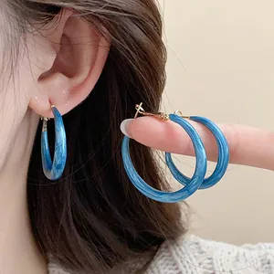 Detailed close-up of vintage blue marbled enamel hoop earrings with 925 silver needles