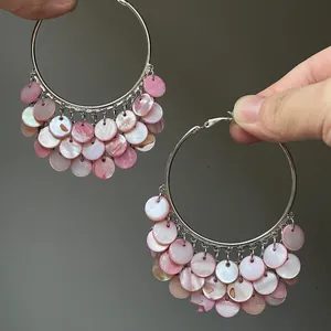 Detail showing pink pearlescent shell discs on large silver hoop earrings for beach