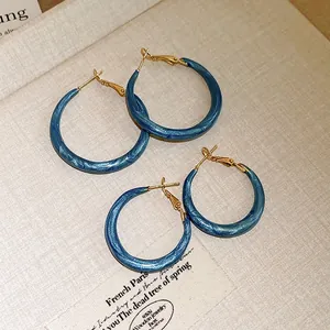 Macro view of vintage blue marbled hoop earrings with shimmering gold accents