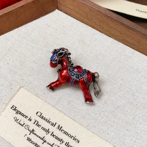 Macro view of an elegant vintage red enamel horse brooch with sparkling rhinestones