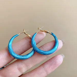 Detail showing the blue marbled enamel texture of these vintage gold-tone hoop earrings