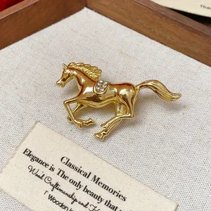 Macro view of a golden running horse brooch with sparkling rhinestone saddle details