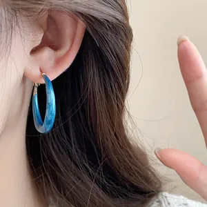 Close-up view of elegant blue marbled resin hoop earrings featuring 925 silver needles