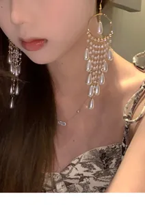 Detail of long pearl tassel earrings in French palace style on an Asian model.