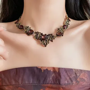 Gros plan d'un collier vintage de style cour avec cristaux rouge foncé sur un mannequin