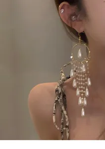 Close-up of French vintage style long fringe earrings with pearls and zircons