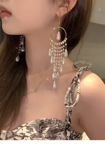 Close-up of elegant long tassel earrings with pearls and crystals on an Asian model