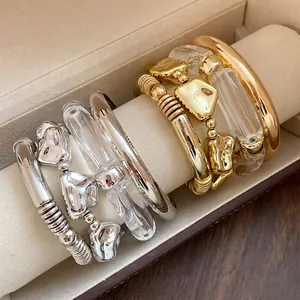 Set of four irregular geometric metal and acrylic bracelets in minimalist gold and silver