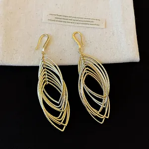 Detailed view of gold-colored layered oval dangle earrings with pleated texture.