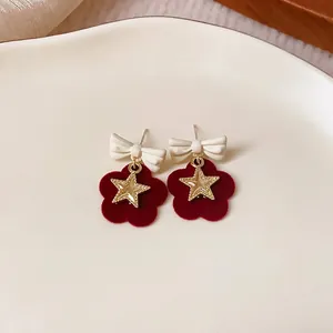 Elegant red flocked flower earrings with white bows and gold stars, perfect for winter