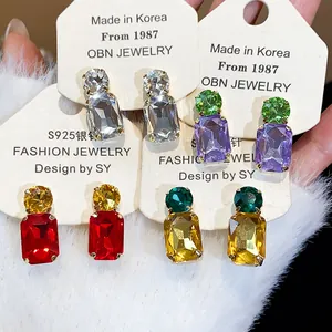 Detailed macro view of square rhinestone stud earrings in various vibrant colors