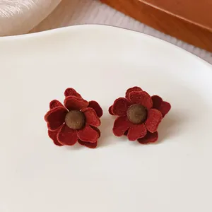 Detailed close-up showing the soft velvet texture of deep red flower stud earrings