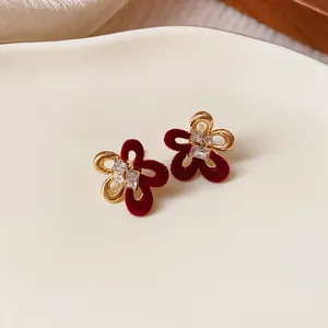 Close-up of red flocked flower earrings with crystals and silver needle for winter.