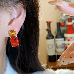 Close-up of sparkling red and yellow crystal stud earrings on an Asian model's ear