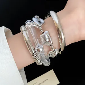 Close-up of a stylish silver-tone and clear acrylic four-piece geometric bracelet set for women