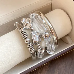 Close-up of 4-piece set including metallic and clear acrylic geometric bracelets