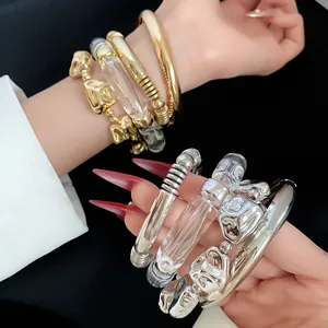 Detail view of a 4-piece chunky metal and clear acrylic irregular geometric bracelet set.