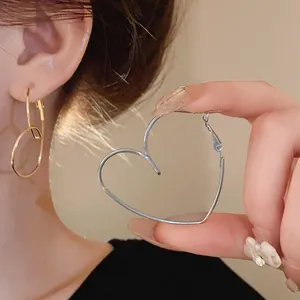 Vue détaillée de boucles d'oreilles délicates en argent en forme de cœur évidé