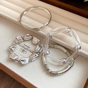 Close-up of four-piece geometric metal and acrylic bracelet set in a jewelry tray