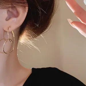 Gros plan détaillé de boucles d'oreilles créoles dorées en forme de cœur portées par un mannequin