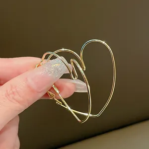 Gros plan sur d'élégantes boucles d'oreilles créoles dorées en forme de cœur évidé