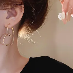 Gros plan montrant l'élégante boucle d'oreille cœur évidé en or minimaliste sur un mannequin.