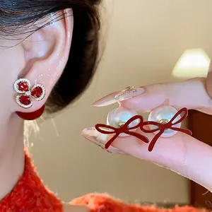 Elegant red flower and pearl bow earrings for a vintage and sophisticated look.
