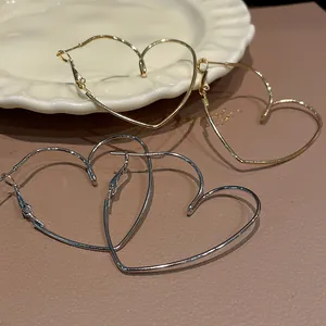 Élégantes créoles dorées et argentées en forme de cœur évidé sur une assiette décorative