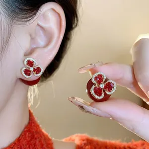 Elegant vintage red flower stud earrings featuring three heart-shaped petals and red pearl backs